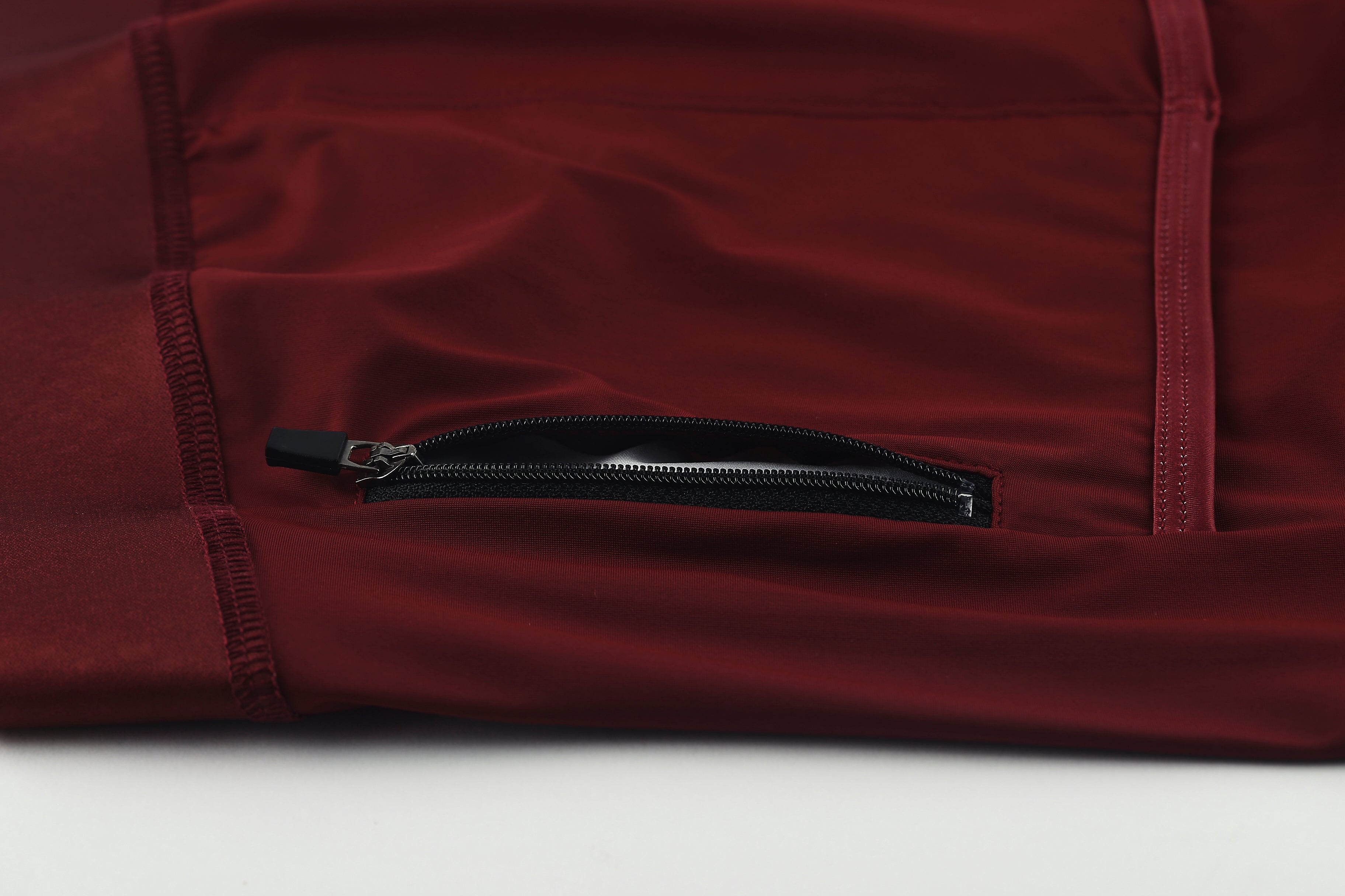 Pinnacle Jersey - Wine - Mens, close-up of wine red fabric with a black zipper pocket.