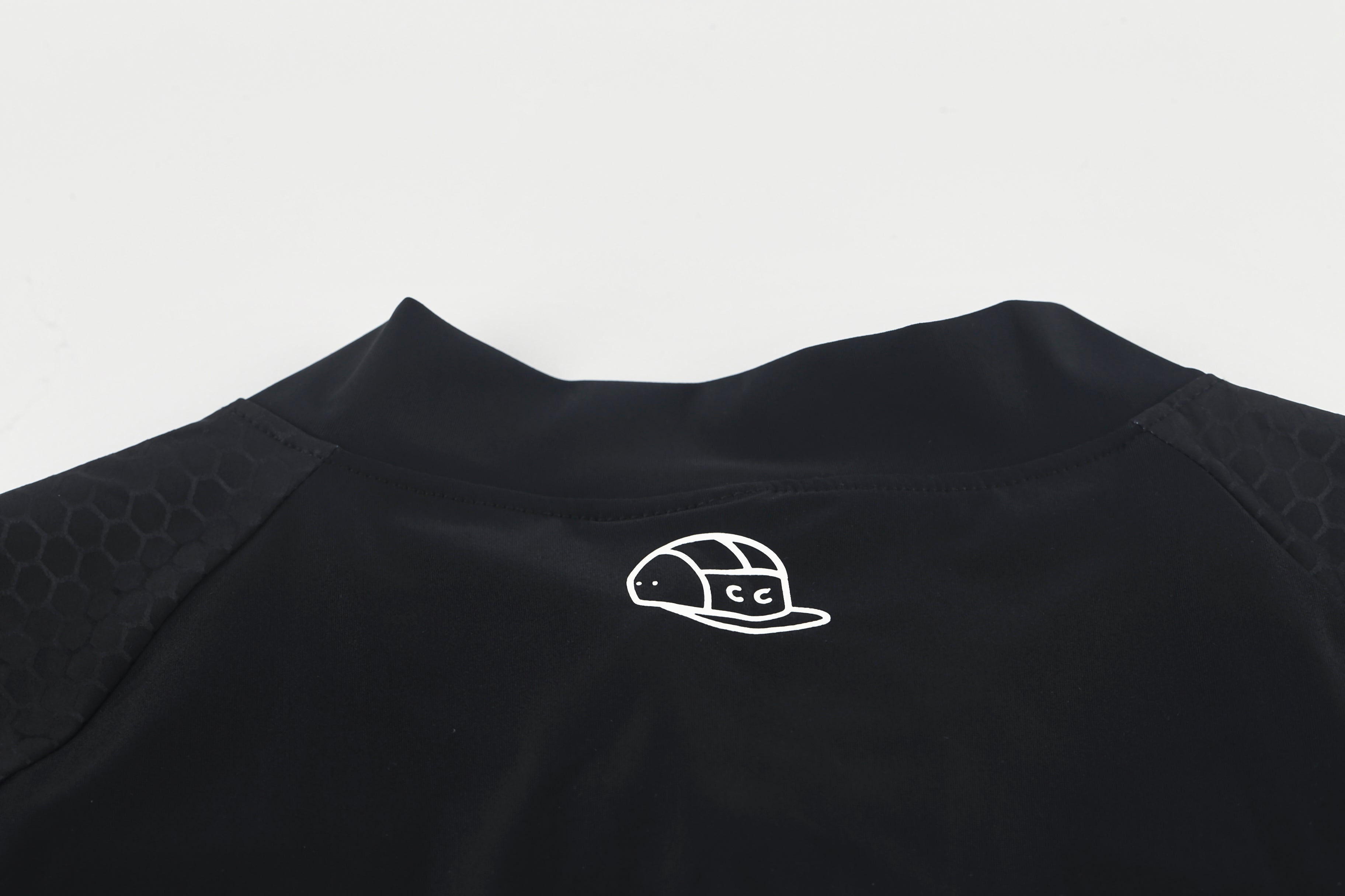 Close-up of black Pinnacle Jersey front with white headset logo.