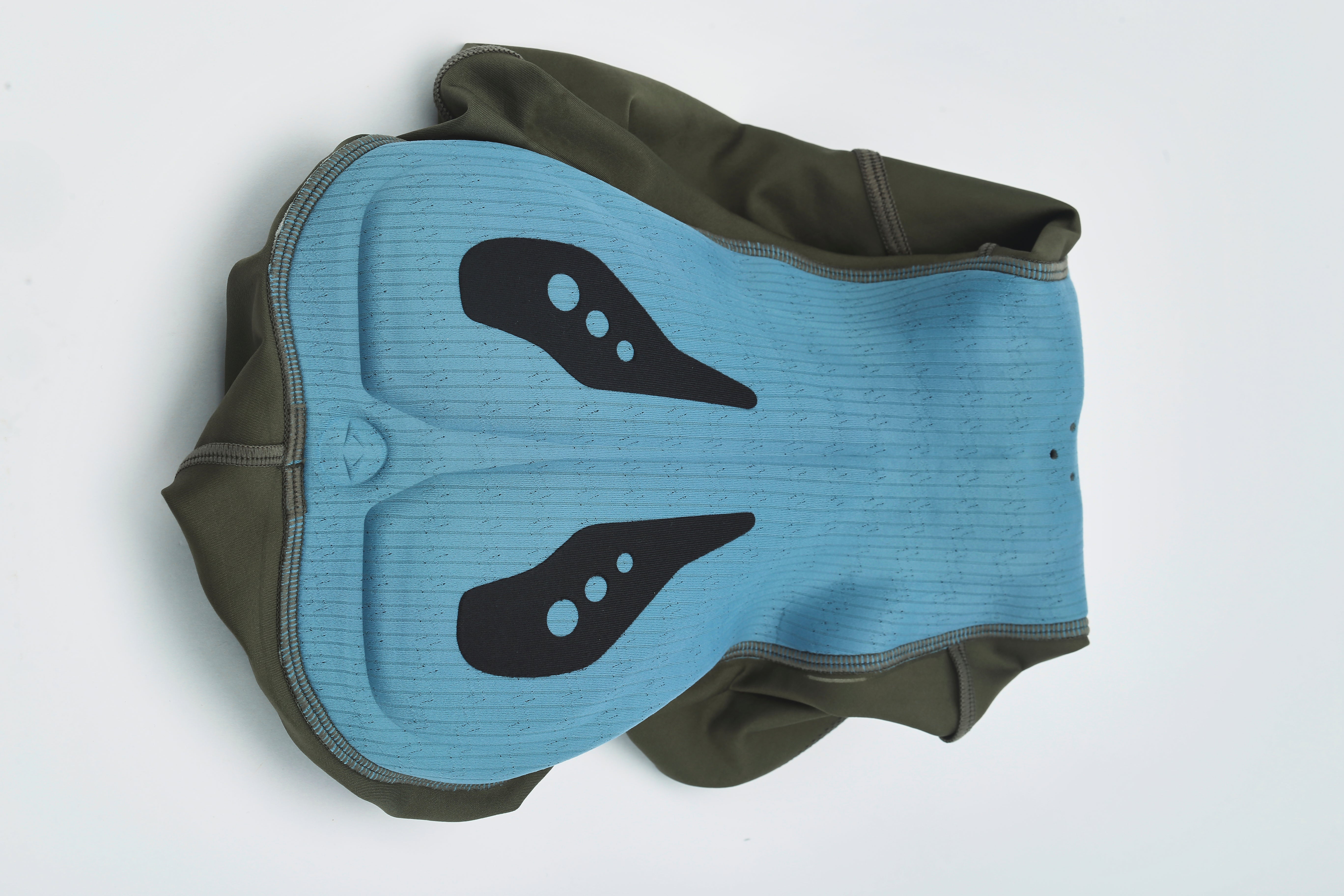 Top-down view of women's olive bib shorts showing blue padded insert with black accent details & ribbed texture.