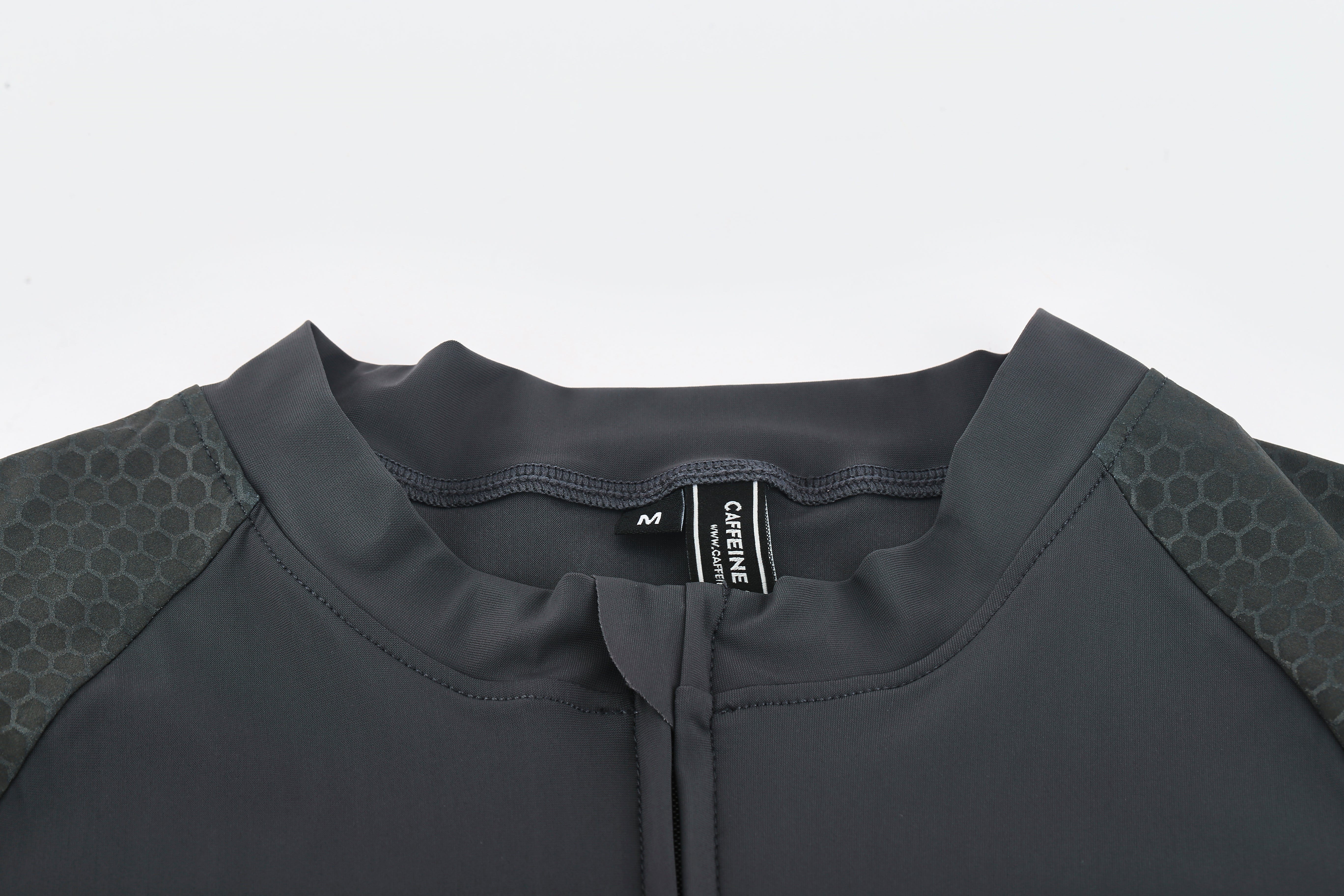 Close-up of men's slate grey Pinnacle Jersey with honeycomb texture on shoulders.