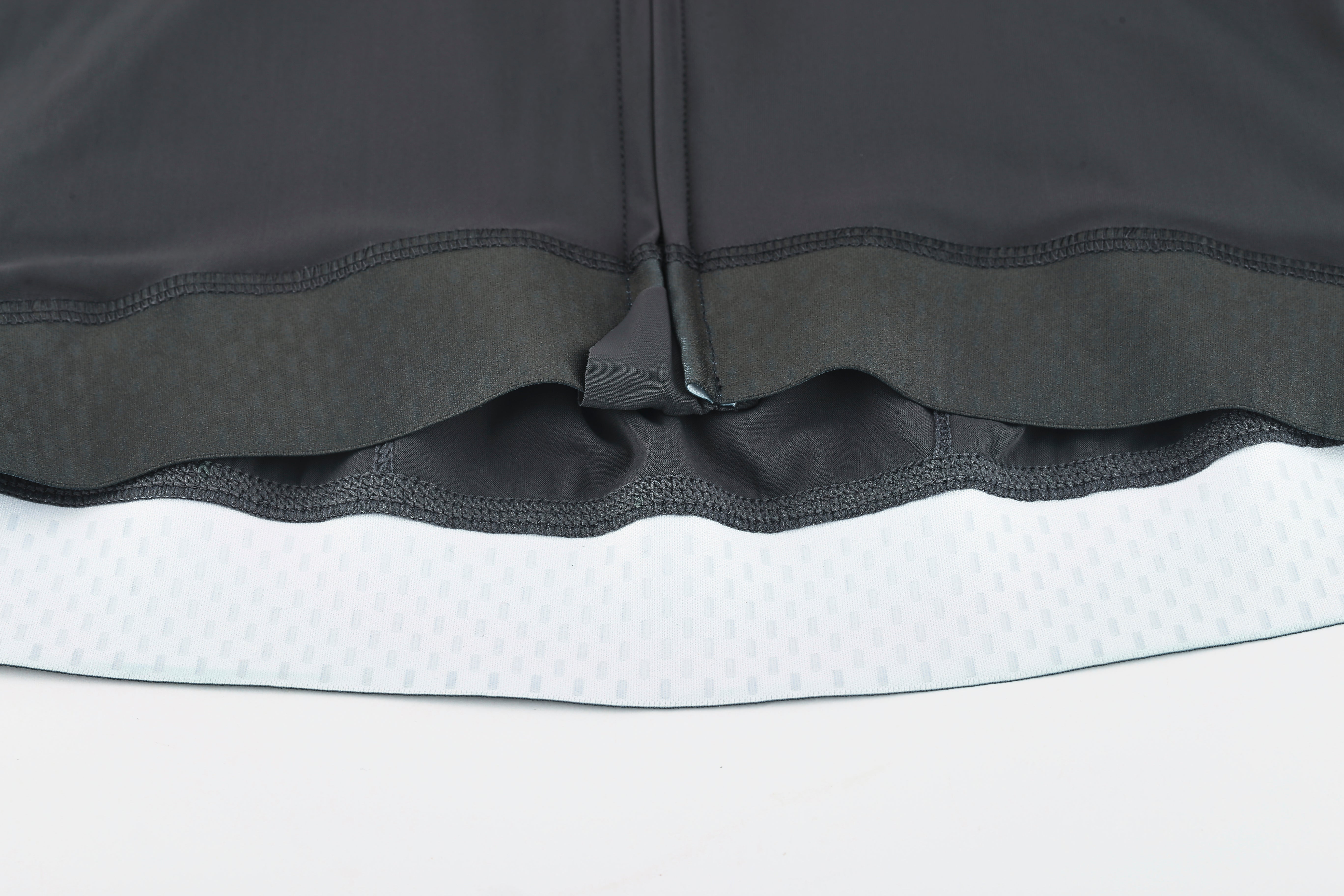 Pinnacle Jersey - Slate - Men's: Close-up of the hem with grey fabric, black gripper band & white patterned lining.